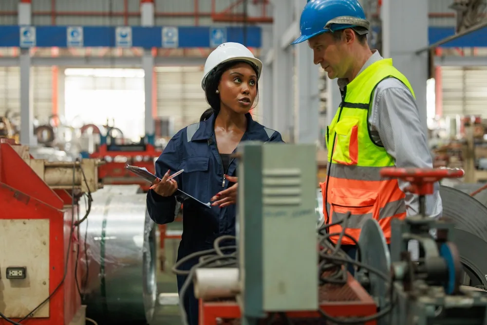 Productiemedewerkers bespreken het werk naast industriële machines