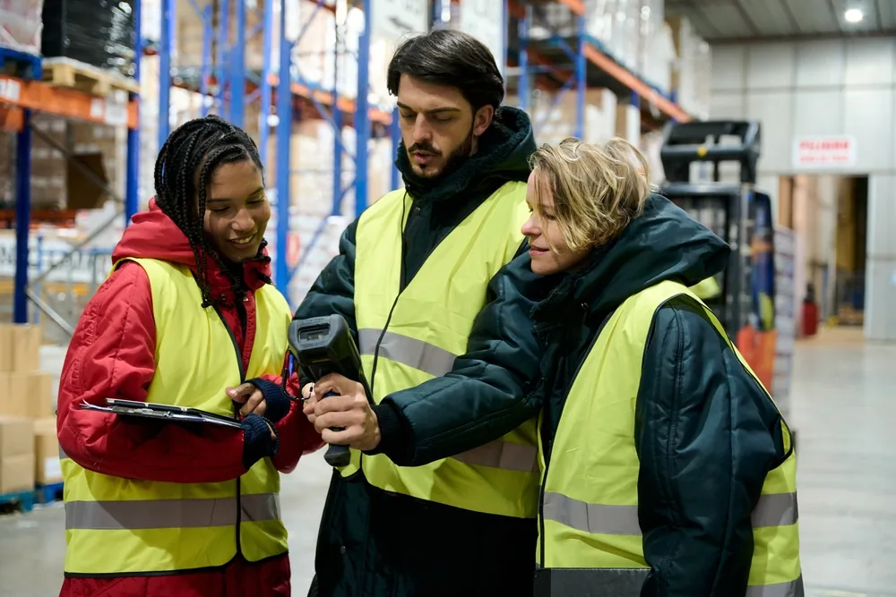 Medewerkers in een magazijn overleggen met scanner en klembord